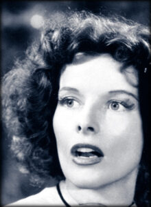 Cropped film still from the 1938 film Bringing Up Baby, featuring Katharine Hepburn and Cary Grant.